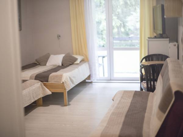 Pokój 4os. na parterze nr.3 z wyjściem na ogród, w pokoju łóżko podwójne ,pojedyncze i kanapa.