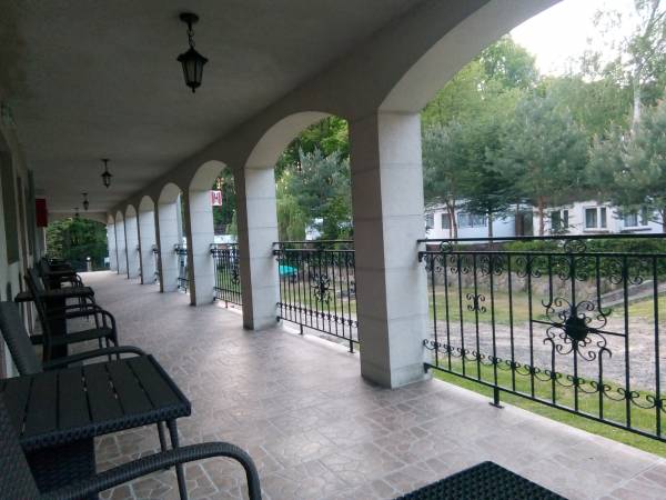 Taras pod filarami z wejściami do pokoi.