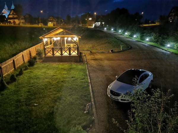 Widok z pokoju na altanę oraz parking