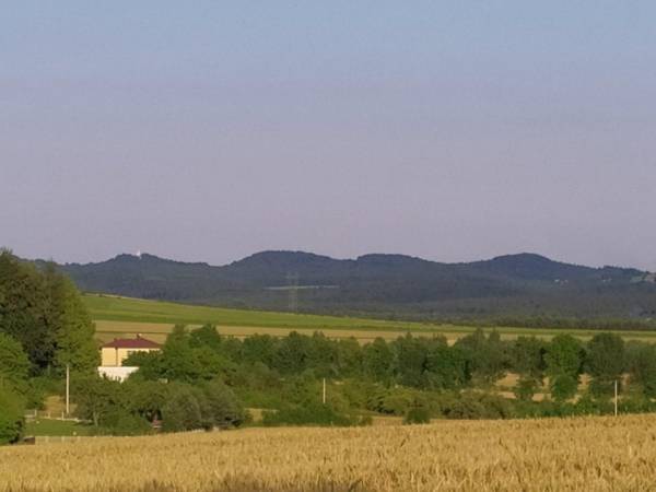 Widok na Zegarowe Skały z białą wieżą zamku Pilcza - widok z podwórka