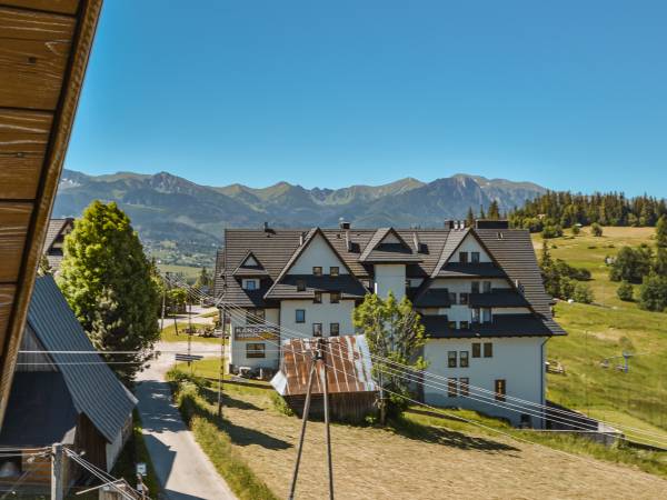Widok na Tatry z Giewontem z 2 piętra, na pierwszym planie karczma pizzeria