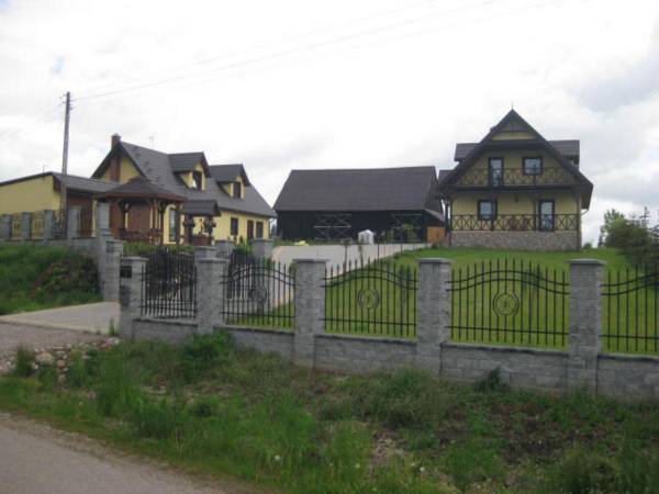 zdjęcie posesji na której są do dyspozycji gości dwa budynki po prawej stronie podwórka i lewej 