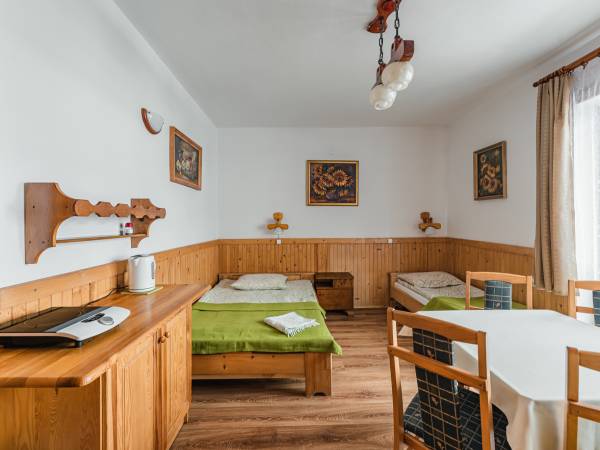 Drugie zdjęcie większego pokoju, lodówka i mikrofala na korytarzu przed pokojami.