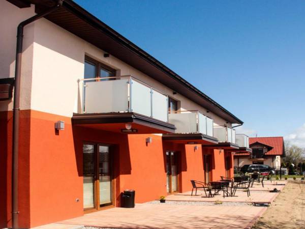 Widok od strony południowo-zachodniej z tarasami na parterze i balkonami na piętrze -