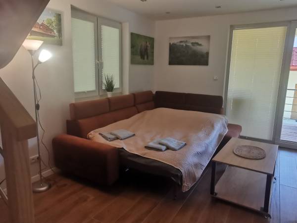 Narożnik po rozłożeniu, wygodne spanie dla 2 osób w salonie nowego domku 