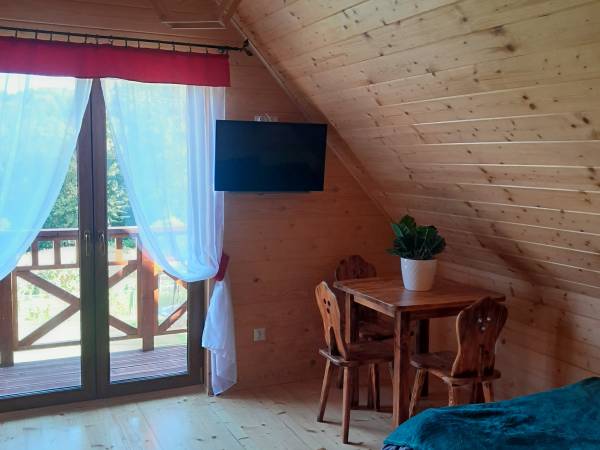 Sypialnia na górze posiada dwa łózka podwójne, stolik i telewizor 