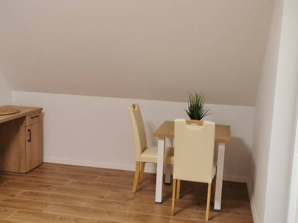 Pokój w nowym domku. Wyposażenie: biurko do pracy i stolik z dwoma wygodnymi krzesłami 