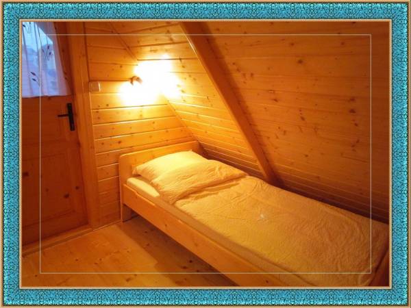 Łóżko w sypialni w domku drewnianym