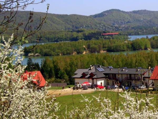 Widok obiektu z tarasu widokowego, w tle Jezioro Solińskie