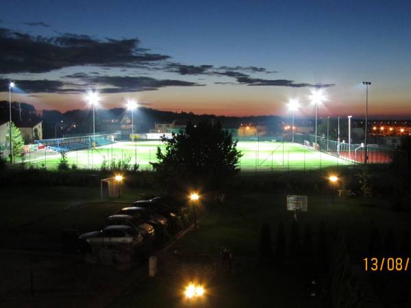 Parking i ogrod w nocy.