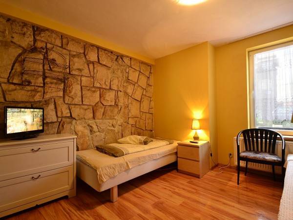 Pokój 2os. na parterze nr.2 z dwoma osobnymi łóżkami i kamienną ścianą.