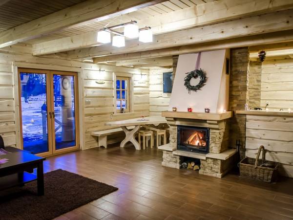 Salon z kominkiem i jadalnią w tle w Suchatce Lawendowej