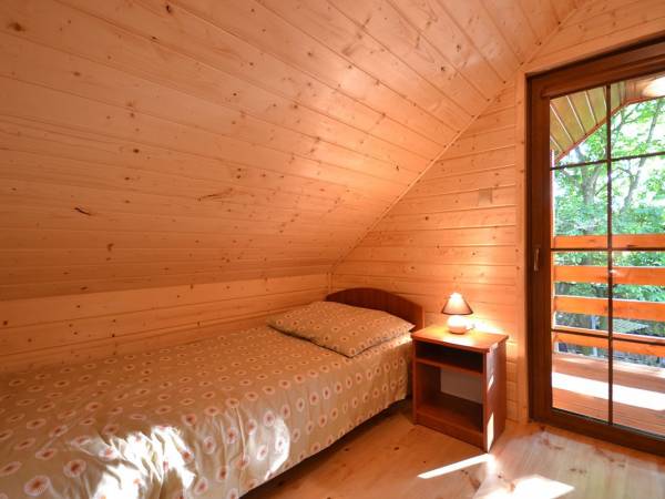 Sypialnia na piętrze z wyjściem na balkon w domkach drewnianych