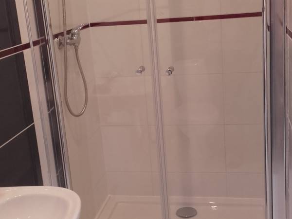 Łazienka w pokoju dwuosobowym z łożem małżeńskim i aneksem.