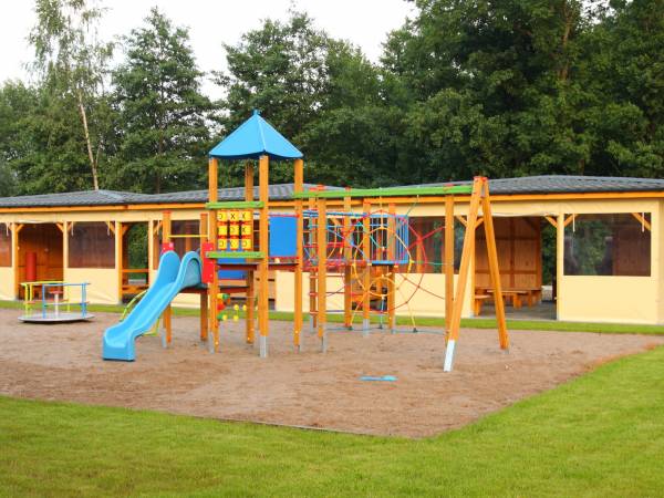 Plac zabaw i grillownia w tle