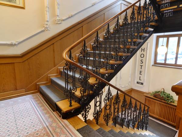 Zabytkowa klatka schodowa prowadząca do recepcji hostelu- I piętro zapraszamy! 