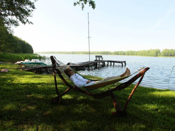 Dojście do jeziora ocienione jest drzewami rzucającymi relaksujący cień.