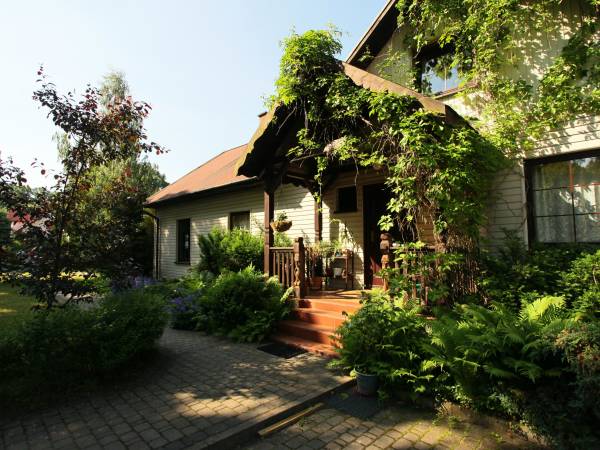 Wejście do domu porośnięte jest winoroślą.