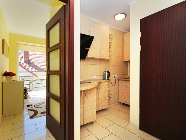 Widok z przedpokoju na sypialnię i aneks kuchenny